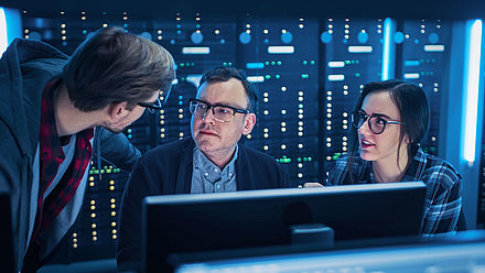 Young IT employees show their boss in the server room how to optimize network security