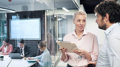 Two employees stand in the office and exchange ideas