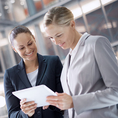 Two female civil servants chat in lobby about the trustworthiness of their network provider