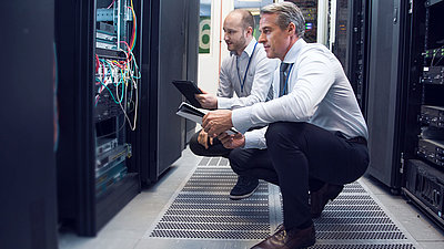 CEO in suit lets IT employee show him firewall in server room