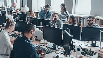 Employees in the office look at a screen