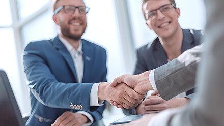 Handshake between business partners symbolizing trust in IT security solutions.