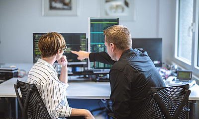 Application developers talking in front of the screen