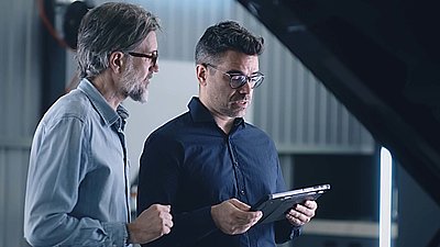 Two men consult about the security of a cloud with a tablet in their hands