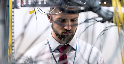 Employee checks the cabling in the server cabinet