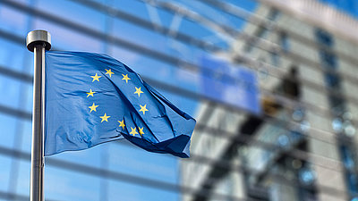 Image of EU flag reflected in window front of building