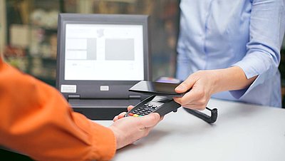 Gentleman in blue shirt pays with smartphone to NFC device