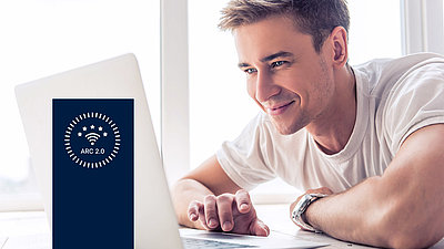 Happy-relaxed young man observes with pleasure the effects of his optimized WLAN on his laptop