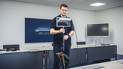 Technician sets up a tripod with an access point