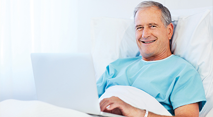 Picture of a man in a hospital with a laptop