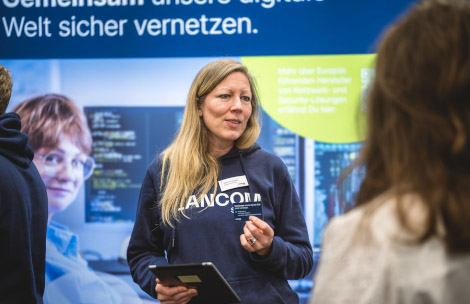 LANCOM Mitarbeiterin informiert Besucher über Arbeitgeberleistungen.