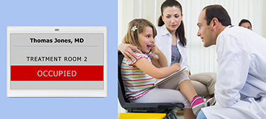 Digital room signage of a treatment room by means of a LANCOM Wirless ePaper Display Digital room signage of a treatment room by means of a LANCOM Wireless ePaper Display. A young girl and her mother are sitting in a treatment room facing a doctor. The young girl is pointing at her teeth.